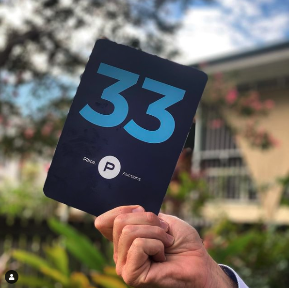 person holding an auction bidder's card