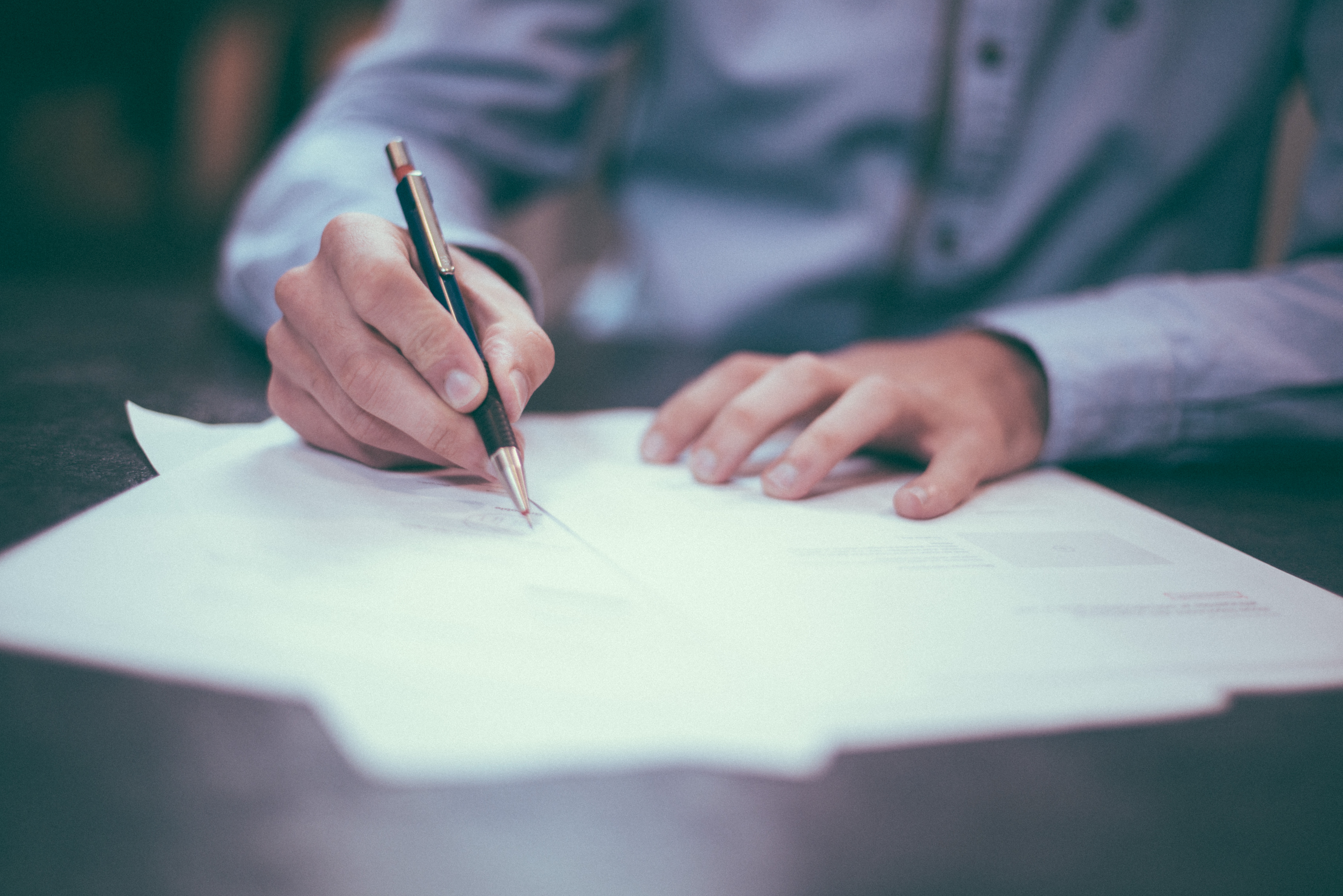 adult man signing a range of papers