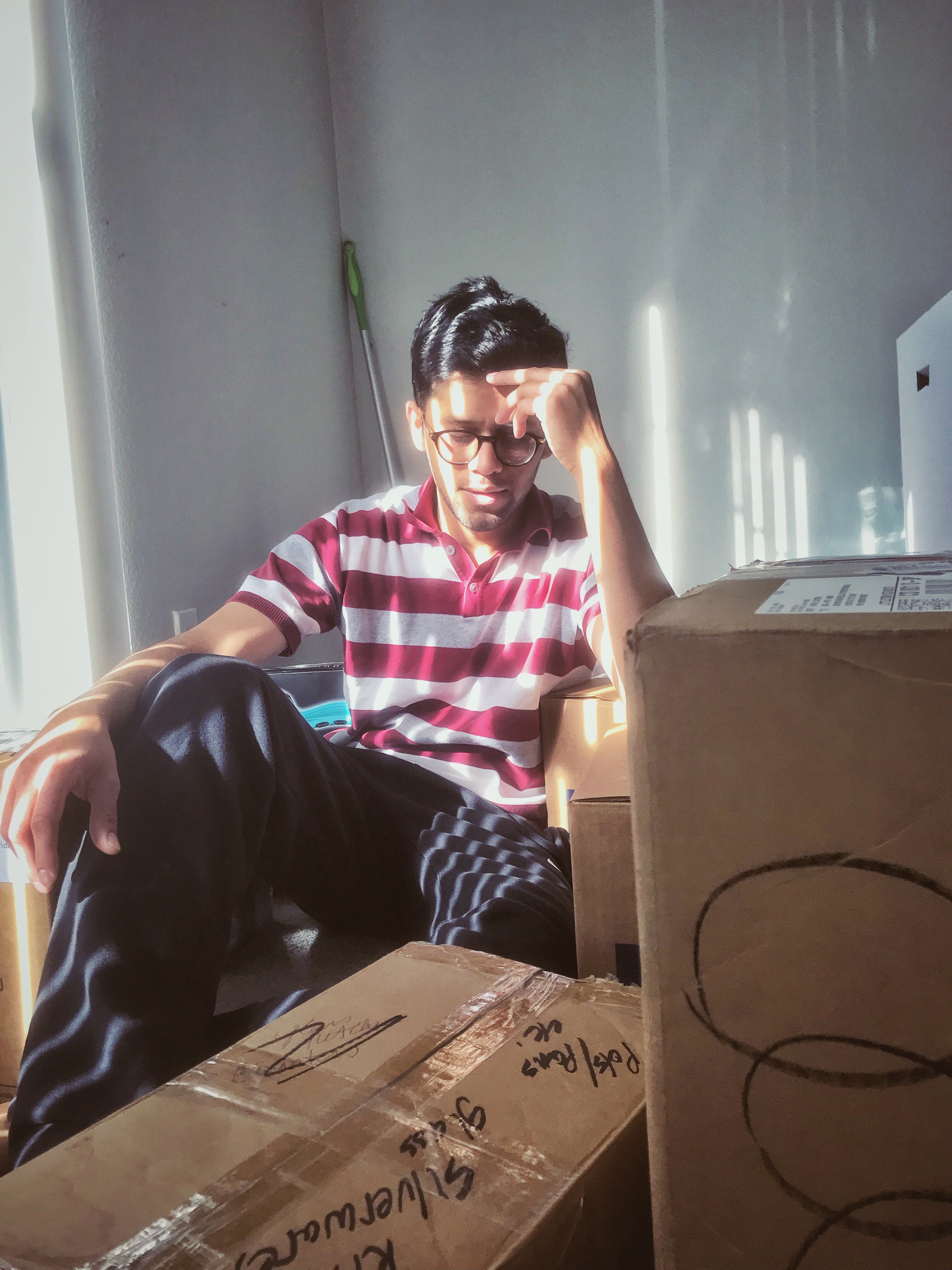 man surrounded by moving boxes