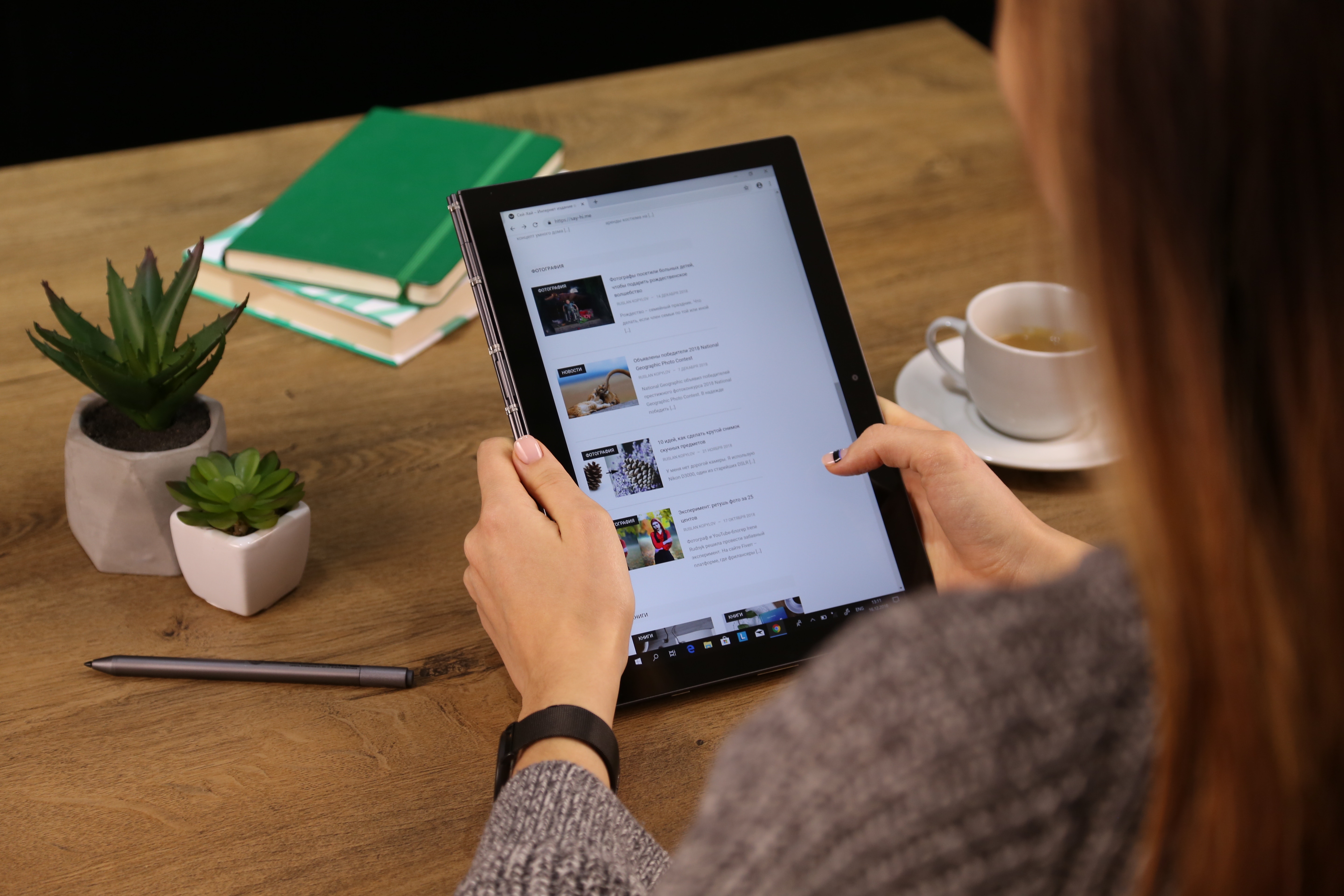 woman scrolling on tablet at desk